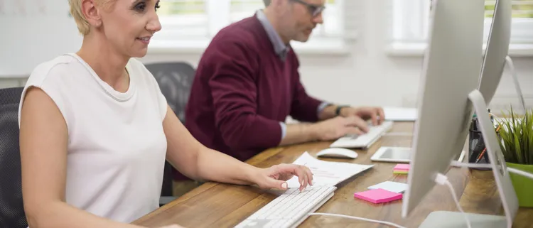 Co workers busy front computers scaled