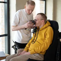 Vriend helpt man met beperking