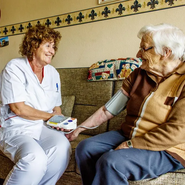 Verpleegkundige meet bloeddruk oudere foto De Stelp