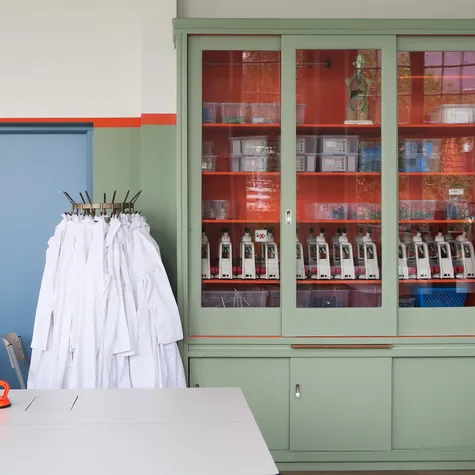 Groene kast in lokaal daarnaast labjassen Foto Koning Ellis Arch