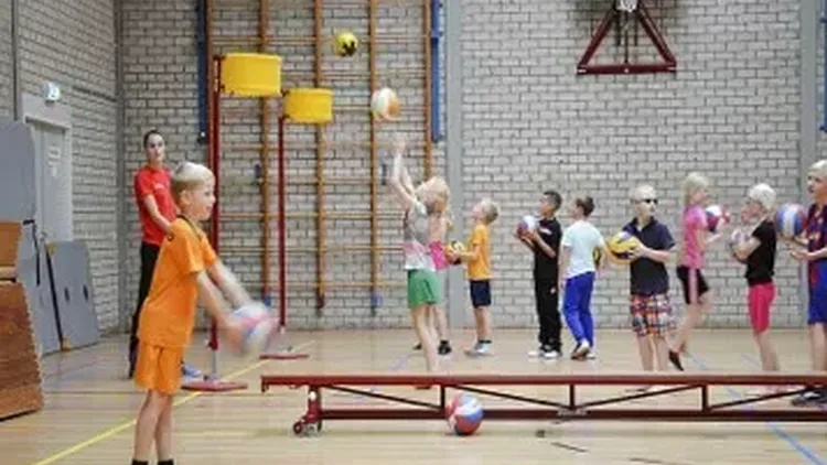 Korfbal spelende kinderen in gymzaal