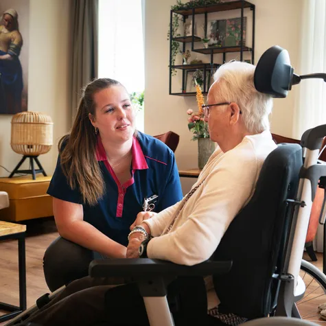 Zorgmedewerker met bewoner in rolstoel - foto Niels Zomer